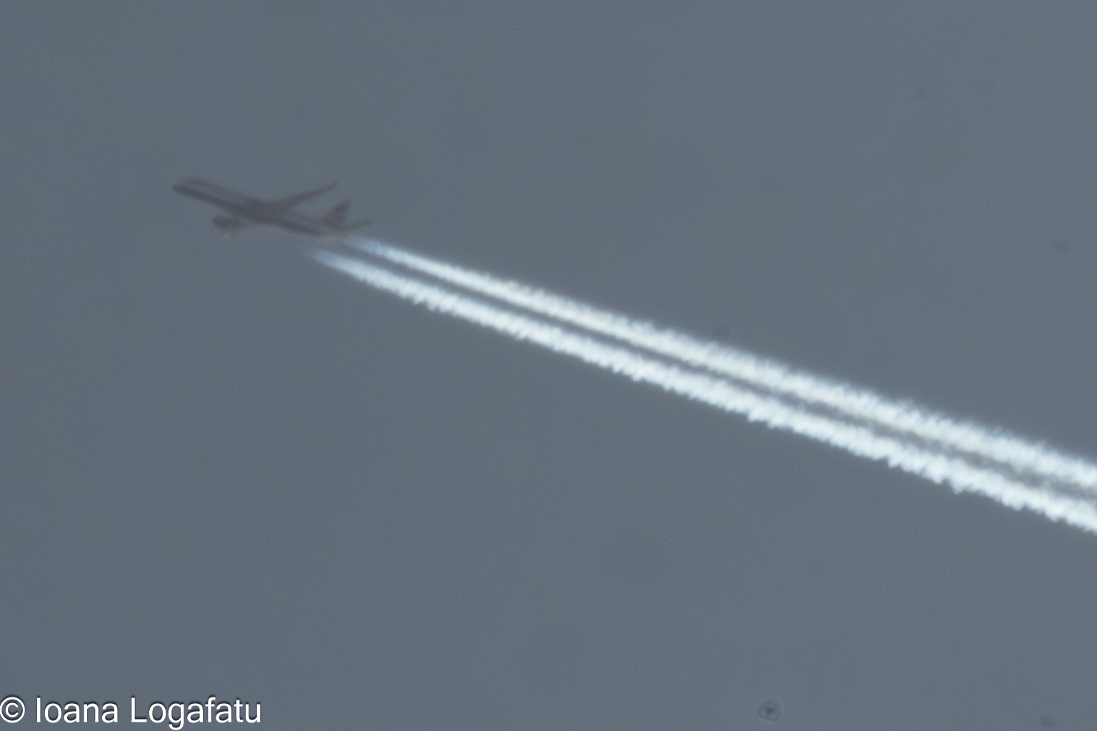 Plane flies through clouds, leaving trails